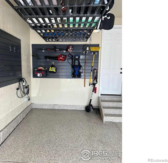 garage featuring baseboards and a textured wall