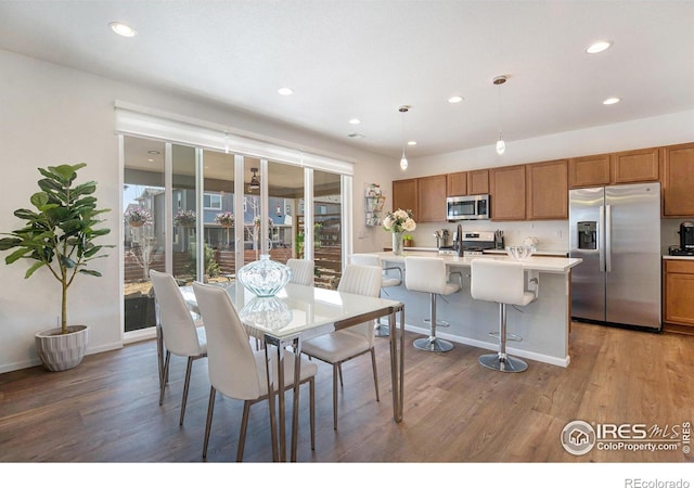 dining space featuring recessed lighting, wood finished floors, and baseboards