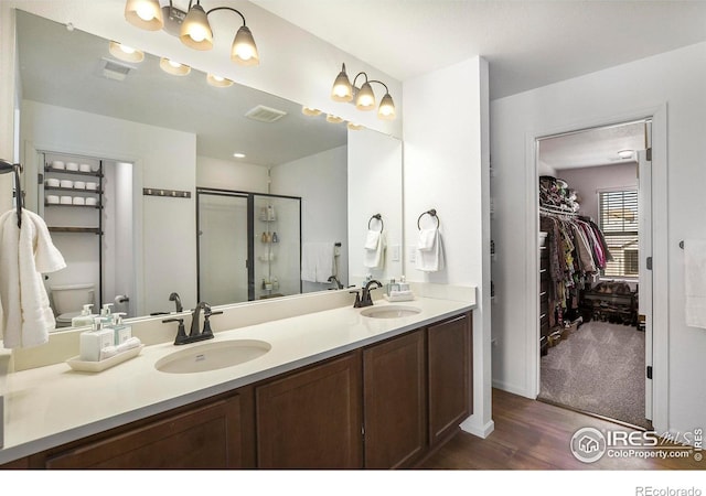 bathroom with a shower stall, visible vents, and a sink