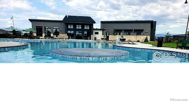 community pool with a patio and fence