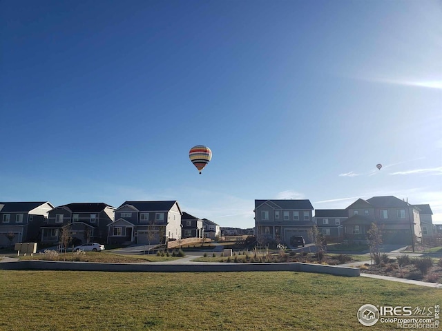 view of home's community featuring a residential view and a lawn