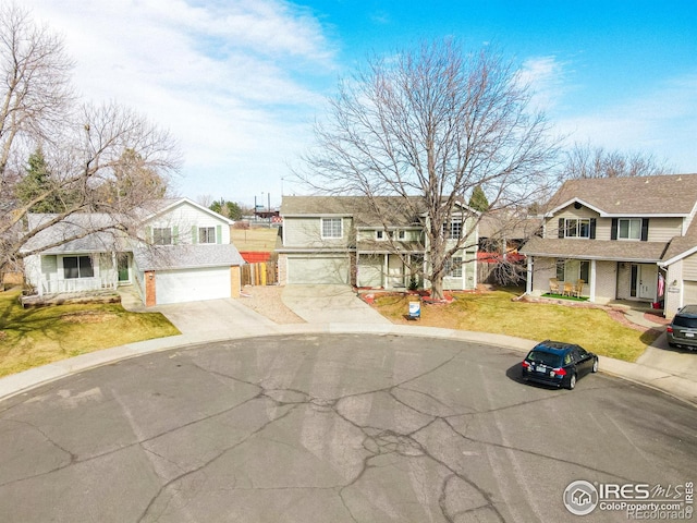 view of front of house featuring a garage, a residential view, a front lawn, and driveway