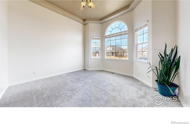 1386 Plains Ct, Eaton, CO 80615 - carpeted spare room with a tray ceiling, a healthy amount of sunlight, baseboards, and ceiling fan