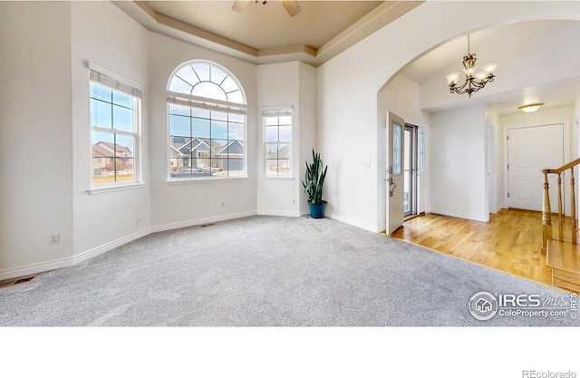 1386 Plains Ct, Eaton, CO 80615 - interior space featuring baseboards, stairway, ceiling fan with notable chandelier, arched walkways, and a raised ceiling
