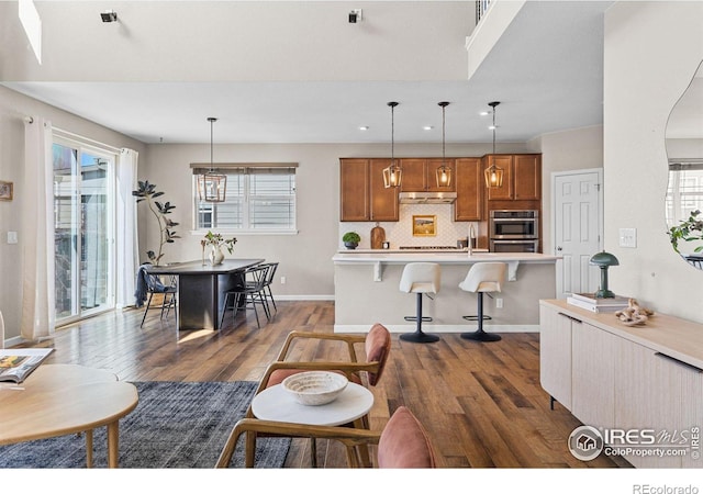 living room with dark wood-type flooring, a healthy amount of sunlight, and baseboards