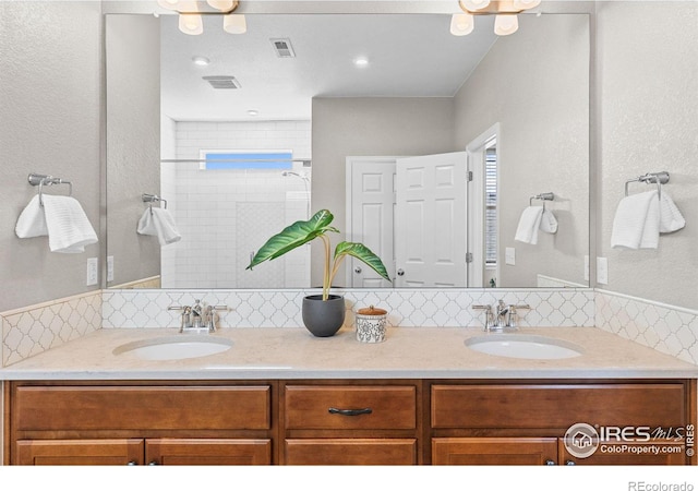 full bathroom with a sink, visible vents, and double vanity