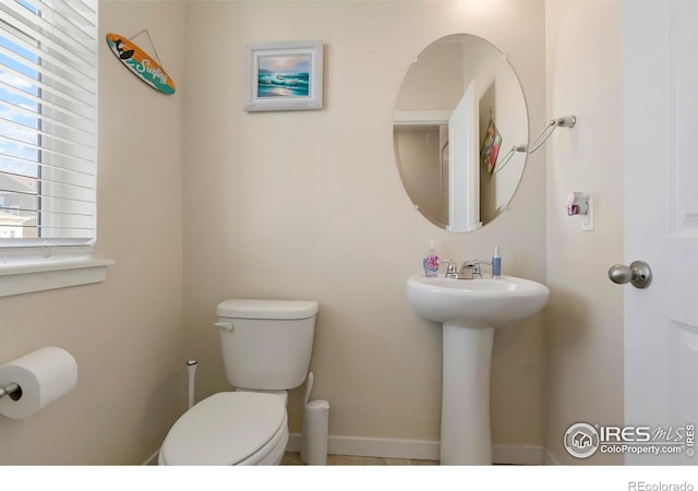 half bathroom with toilet and baseboards