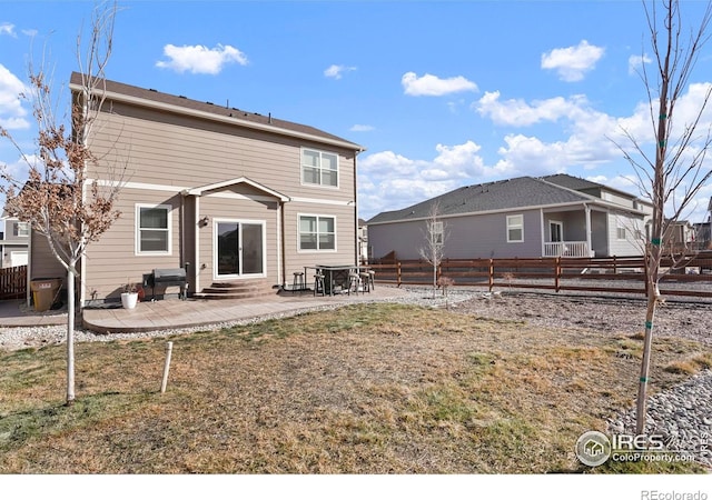 rear view of house featuring entry steps, a patio area, and a fenced backyard