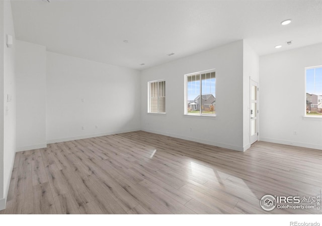 spare room with recessed lighting, baseboards, and light wood-style floors