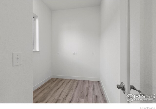 empty room with light wood-type flooring and baseboards