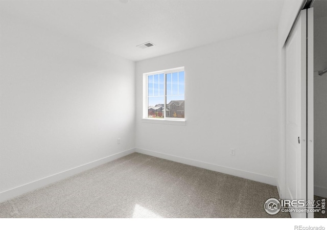 unfurnished bedroom featuring a closet, visible vents, baseboards, and carpet floors