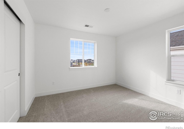 unfurnished bedroom featuring visible vents, baseboards, a closet, and carpet flooring