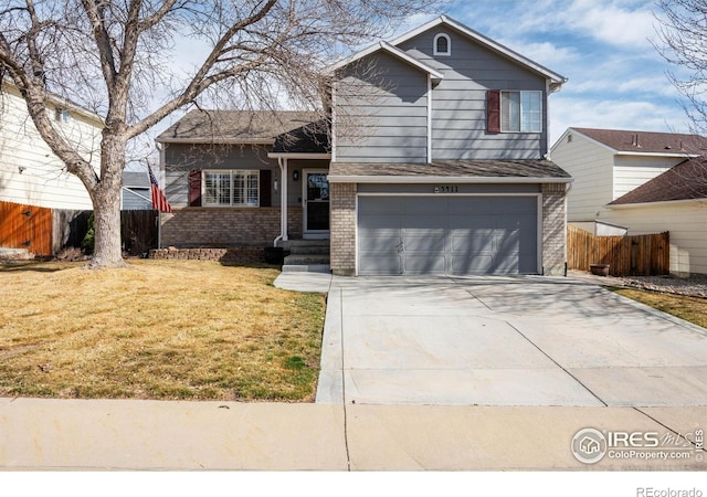 split level home featuring brick siding, a front lawn, fence, driveway, and an attached garage