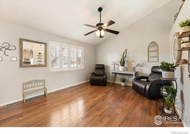 living area with visible vents, lofted ceiling, wood finished floors, and a ceiling fan