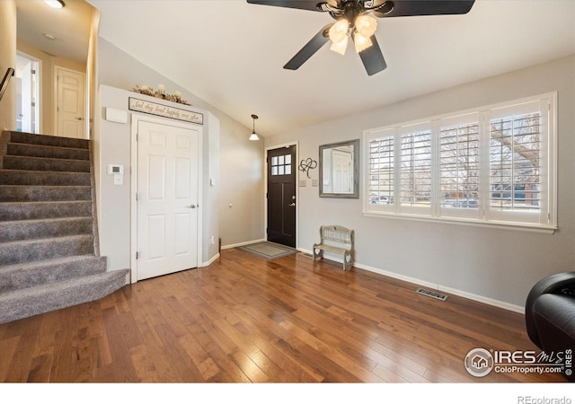 foyer featuring visible vents, lofted ceiling, wood-type flooring, and stairway