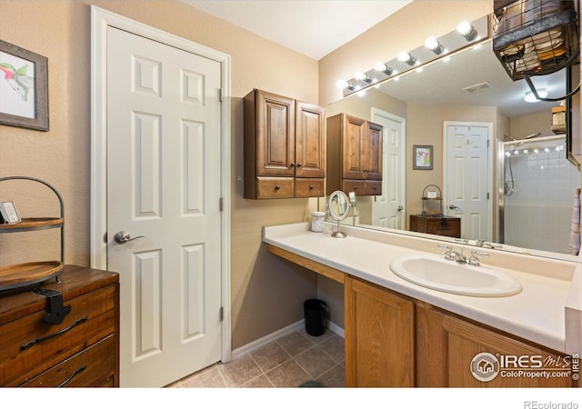 full bath featuring vanity, baseboards, visible vents, tile patterned flooring, and a shower stall