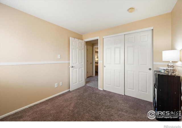 unfurnished bedroom featuring a closet, baseboards, and carpet