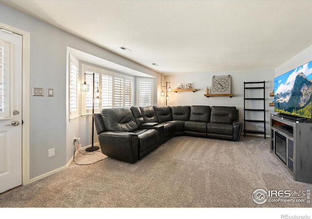 carpeted living area featuring baseboards and visible vents