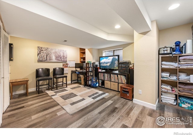 living area featuring recessed lighting, baseboards, and wood finished floors