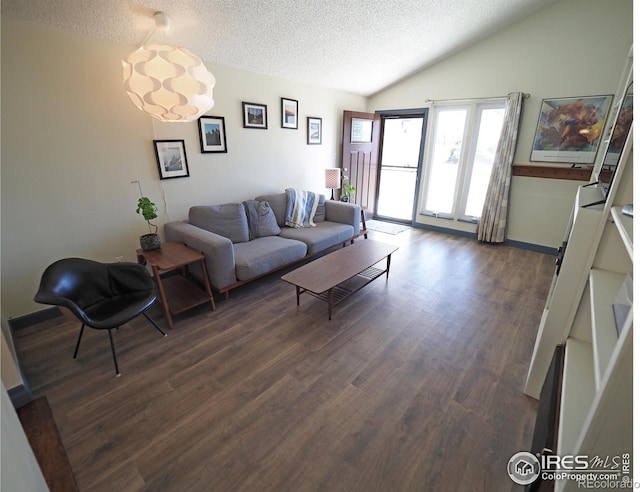 living room with dark wood-style floors, a textured ceiling, and vaulted ceiling