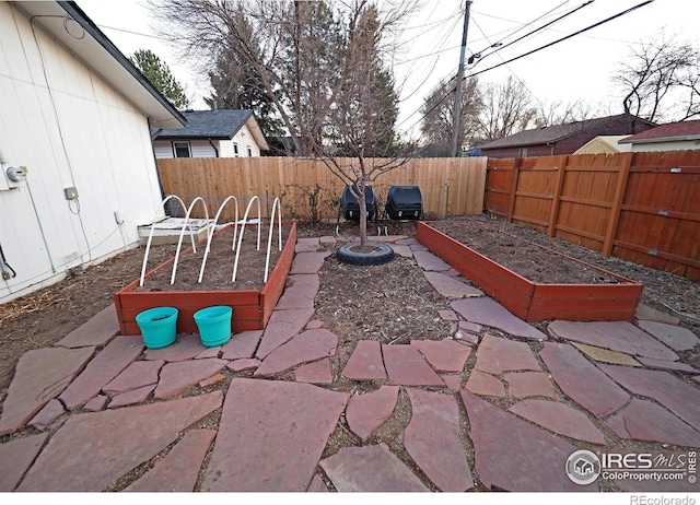 view of patio / terrace with a fenced backyard and a vegetable garden