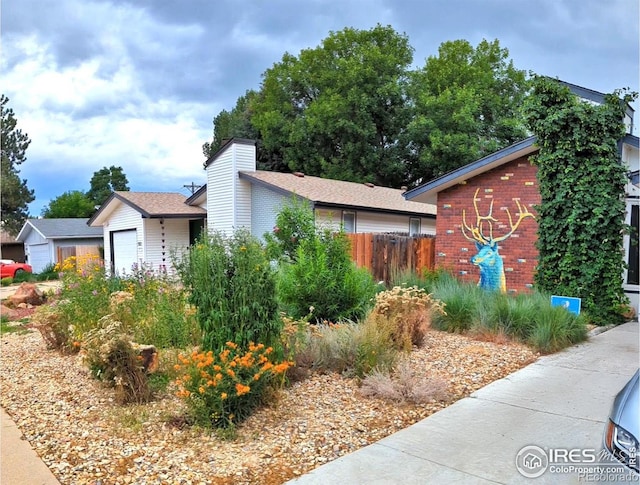 mid-century inspired home with fence, brick siding, and a chimney