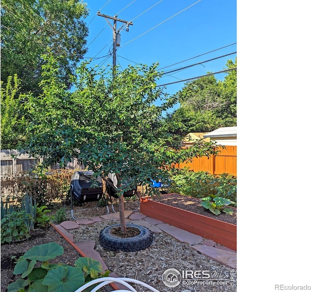 view of patio / terrace with a vegetable garden and fence