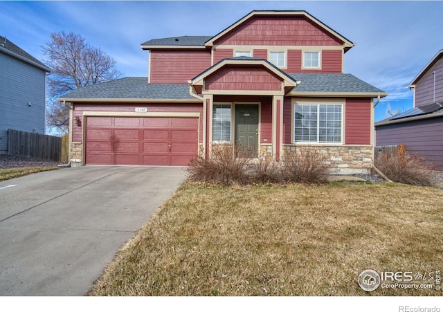 view of front of house featuring a front lawn, fence, concrete driveway, stone siding, and an attached garage