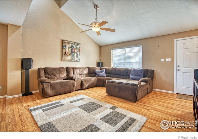 living room with light wood-style flooring, baseboards, high vaulted ceiling, and ceiling fan