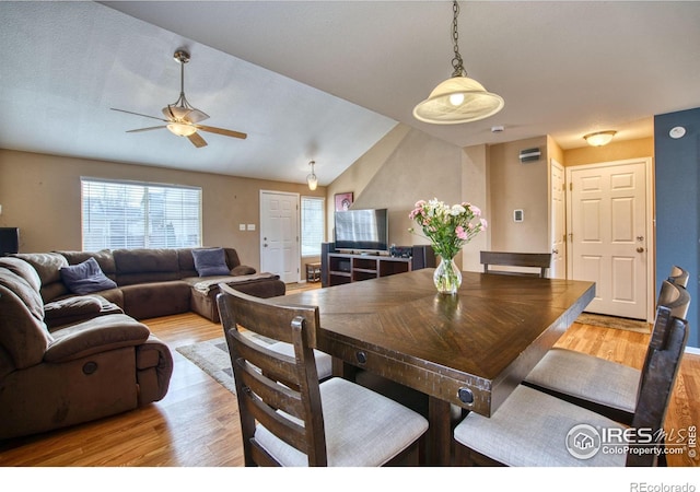 dining room with light wood-style flooring, lofted ceiling, and ceiling fan