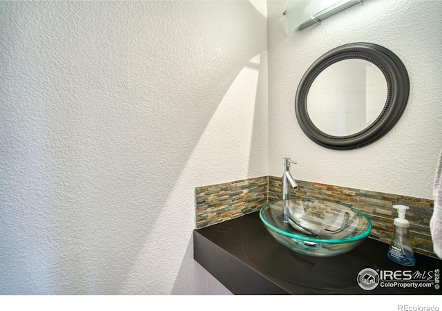 bathroom with a textured wall and a sink