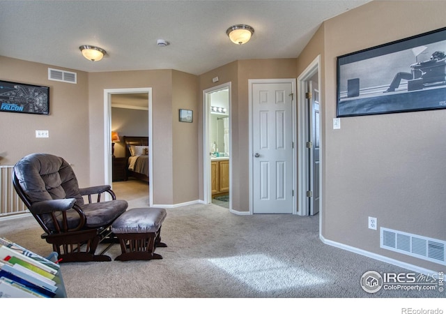 living area with visible vents, baseboards, and carpet