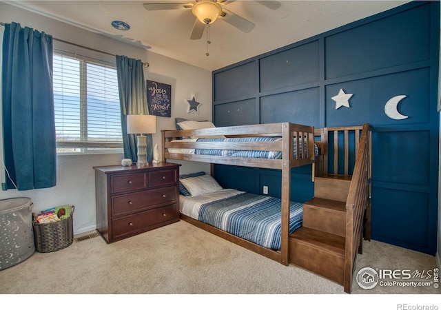 carpeted bedroom featuring a decorative wall