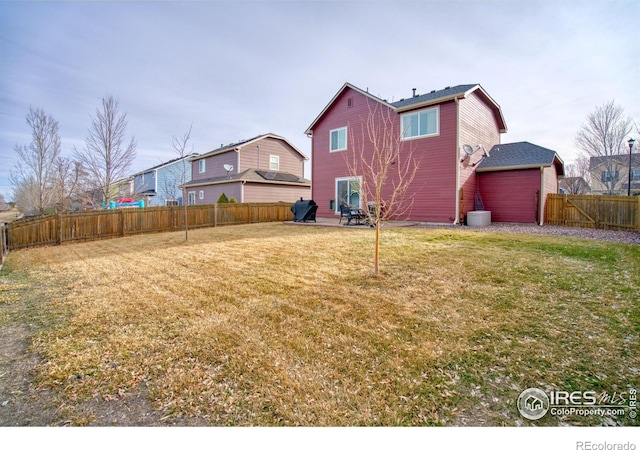 rear view of property with a lawn and a fenced backyard