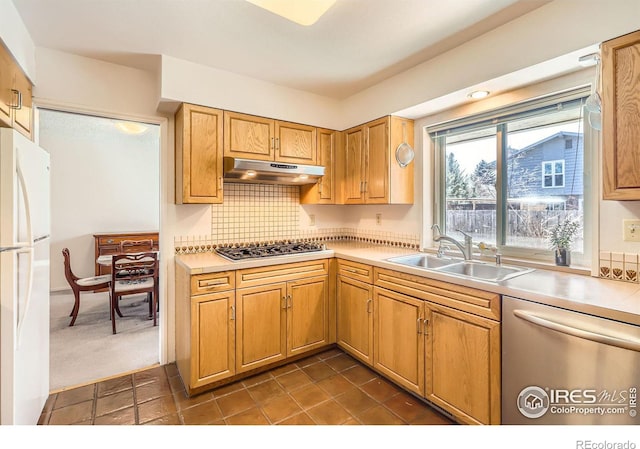 kitchen with under cabinet range hood, stainless steel appliances, light countertops, and a sink