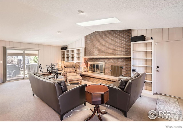 living area featuring lofted ceiling with skylight, a textured ceiling, a brick fireplace, and carpet flooring