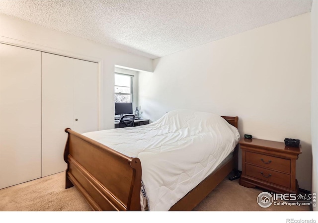 bedroom with carpet flooring, a closet, and a textured ceiling