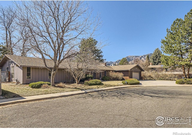 view of front facade featuring a mountain view, board and batten siding, an attached garage, and concrete driveway