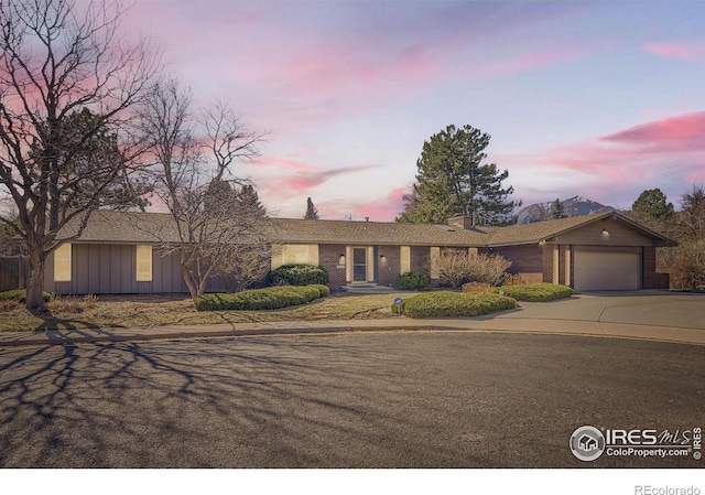 ranch-style home with driveway, brick siding, and an attached garage