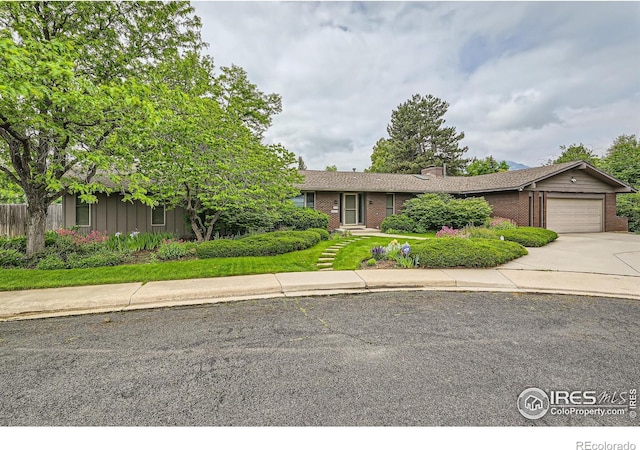 325 Fox Ct, Boulder, CO 80303 - view of front of property with brick siding, an attached garage, driveway, and a chimney