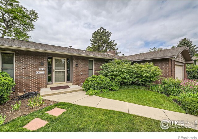 325 Fox Ct, Boulder, CO 80303 - ranch-style home featuring brick siding, a front yard, a garage, and a chimney