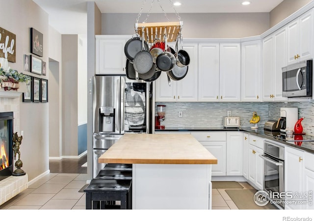 2073 River W Dr, Windsor, CO 80550 - kitchen with backsplash, appliances with stainless steel finishes, butcher block counters, and light tile patterned flooring
