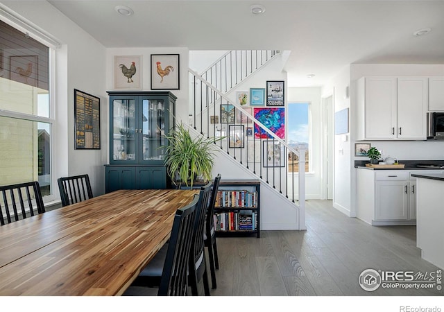 dining room with stairs and wood finished floors