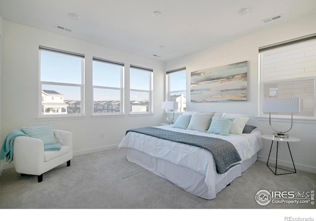 carpeted bedroom featuring visible vents and baseboards