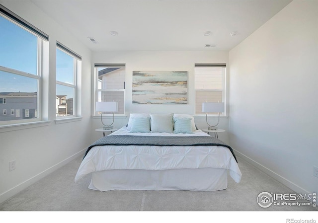 carpeted bedroom featuring visible vents and baseboards