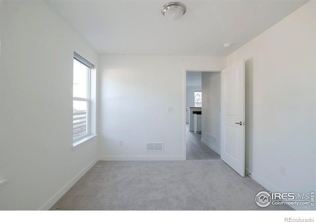 carpeted empty room with visible vents and baseboards