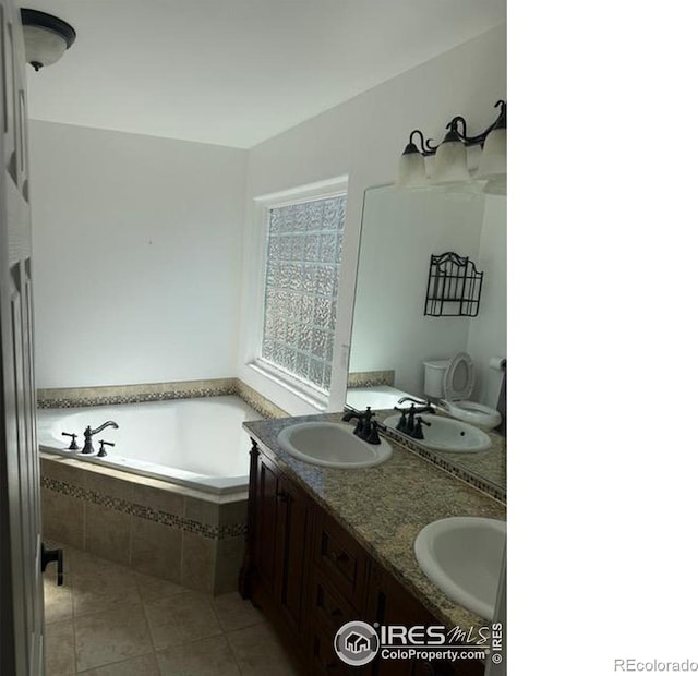 bathroom featuring a sink, a garden tub, double vanity, and tile patterned flooring