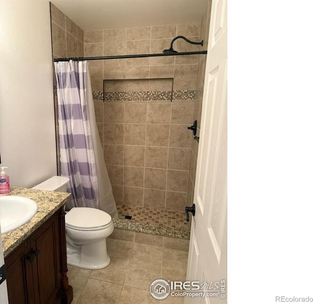 bathroom with tile patterned flooring, toilet, a stall shower, and vanity