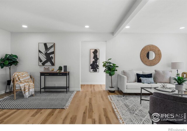 sitting room with beamed ceiling, recessed lighting, baseboards, and wood finished floors