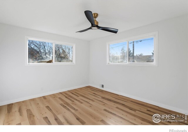 empty room with visible vents, a healthy amount of sunlight, and wood finished floors